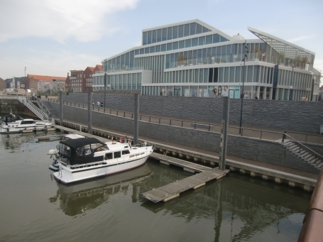 Venlo : Alter Stadthafen und De Maaspoort im Hintergrund. De Maaspoort, ist ein Theater und Konferenzzentrum, das auf der zweiten Etage ( neues Theater ) untergebracht ist. Im Erdgeschoss befindet sich ein Frauen- und Herrenbekleidungsgeschäft.